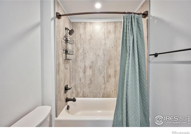 bathroom featuring toilet and shower / bath combo with shower curtain