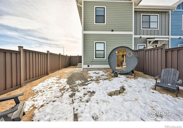 view of snow covered rear of property