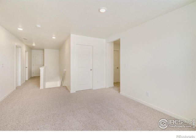 spare room featuring light colored carpet