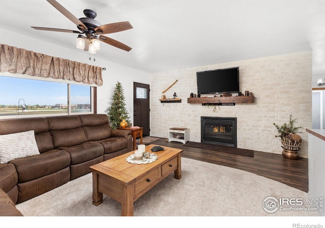 living room with hardwood / wood-style floors, a large fireplace, and ceiling fan