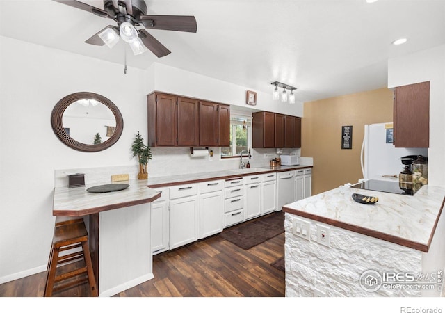 kitchen featuring white cabinetry, dark hardwood / wood-style flooring, kitchen peninsula, and sink