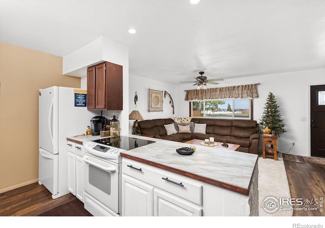 kitchen with kitchen peninsula, white appliances, ceiling fan, white cabinets, and dark hardwood / wood-style floors