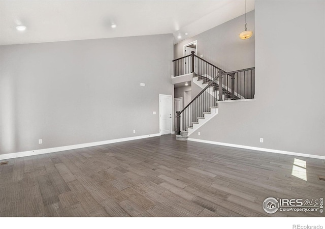 unfurnished living room featuring hardwood / wood-style flooring and high vaulted ceiling