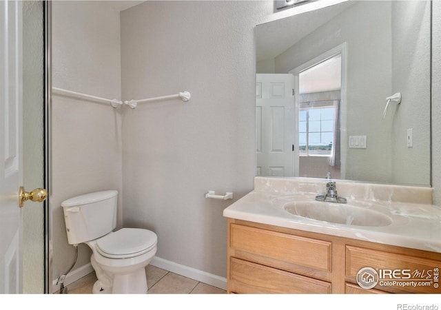 bathroom with tile patterned flooring, vanity, and toilet