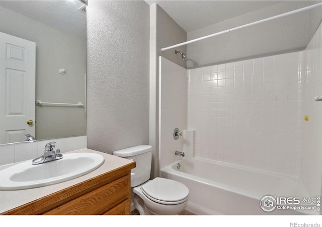 full bathroom featuring vanity, a textured ceiling, toilet, and washtub / shower combination