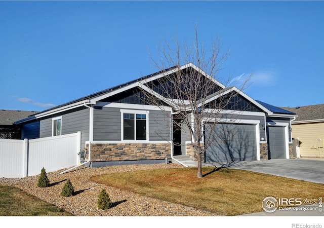 craftsman house with a garage and a front lawn