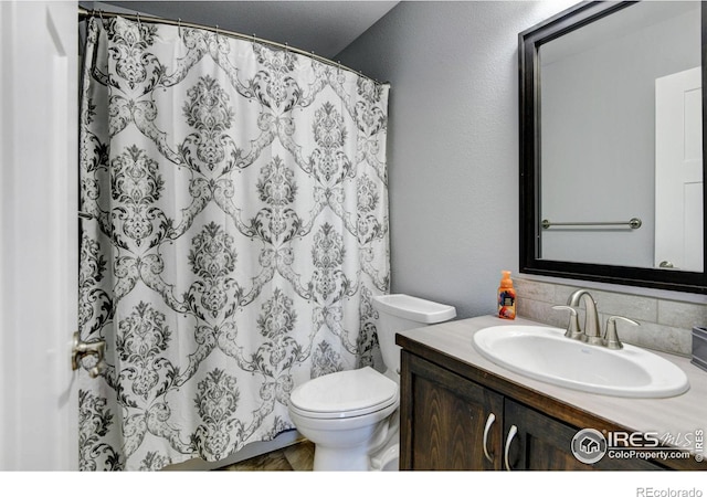 bathroom with vanity, curtained shower, and toilet