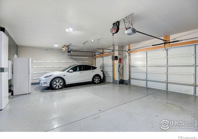 garage with a garage door opener and white fridge