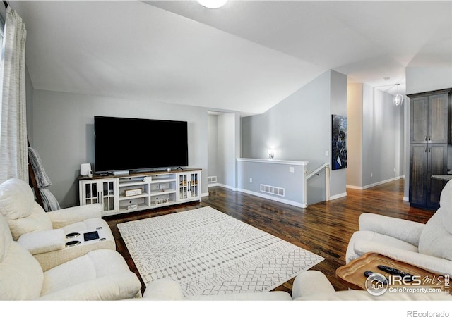 living room featuring lofted ceiling and dark hardwood / wood-style flooring