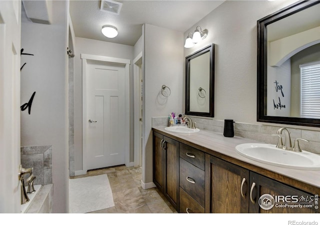 bathroom with vanity and a tub