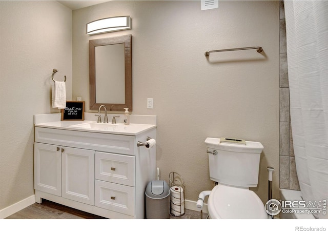 bathroom featuring vanity, wood-type flooring, walk in shower, and toilet