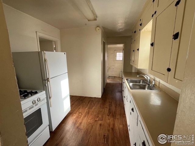 kitchen with white cabinets, dark hardwood / wood-style floors, white gas range, and sink