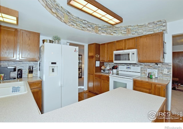 kitchen with decorative backsplash, sink, white appliances, and hardwood / wood-style flooring