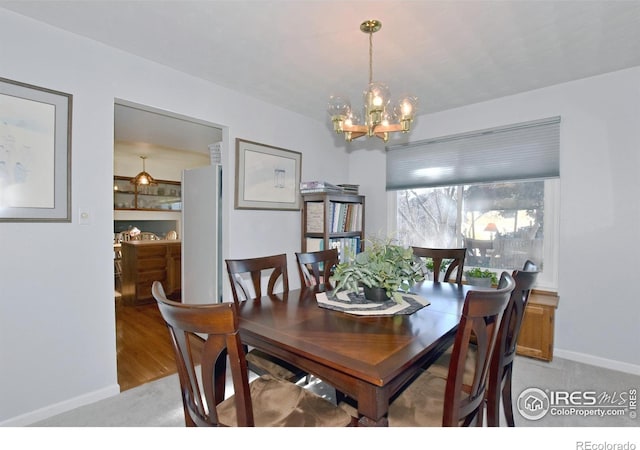 carpeted dining space featuring a chandelier