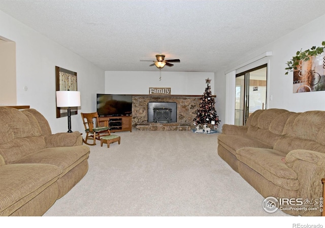 living room featuring carpet, ceiling fan, a wood stove, and a textured ceiling