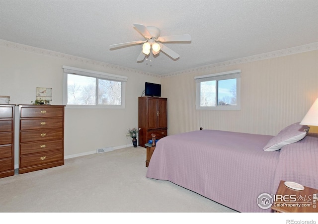 carpeted bedroom with a textured ceiling, multiple windows, and ceiling fan