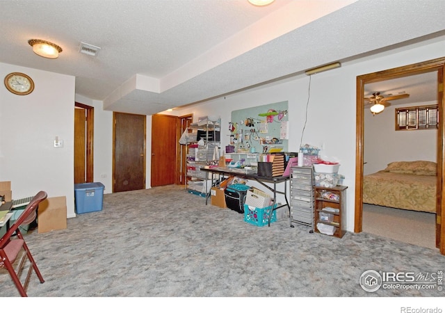 misc room with a textured ceiling, carpet floors, and ceiling fan