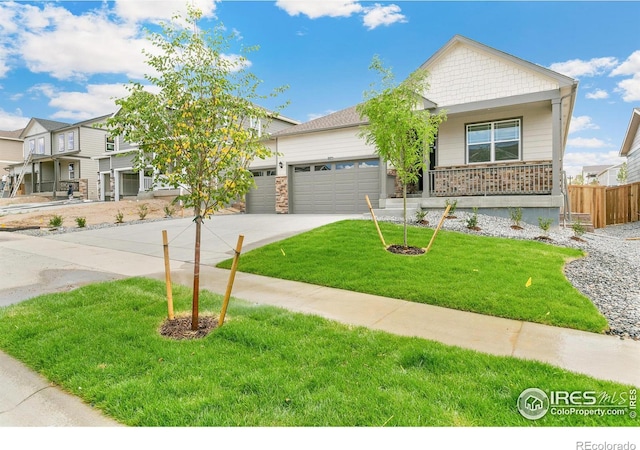 view of front of property with a porch, a garage, and a front lawn