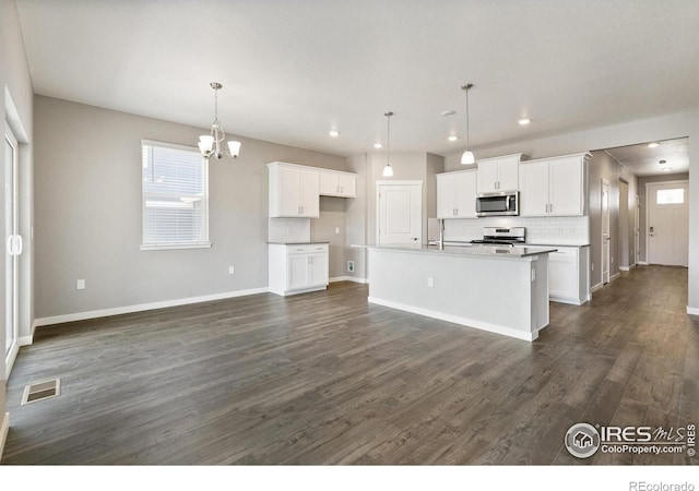 kitchen featuring white cabinets, a center island with sink, and a wealth of natural light