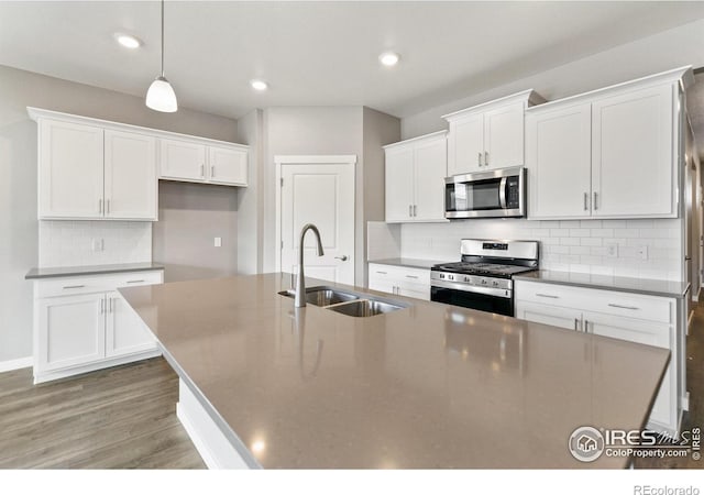 kitchen featuring white cabinetry, sink, appliances with stainless steel finishes, and an island with sink