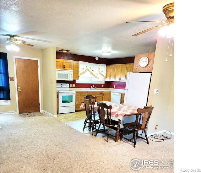 kitchen featuring light carpet, a textured ceiling, white appliances, and sink