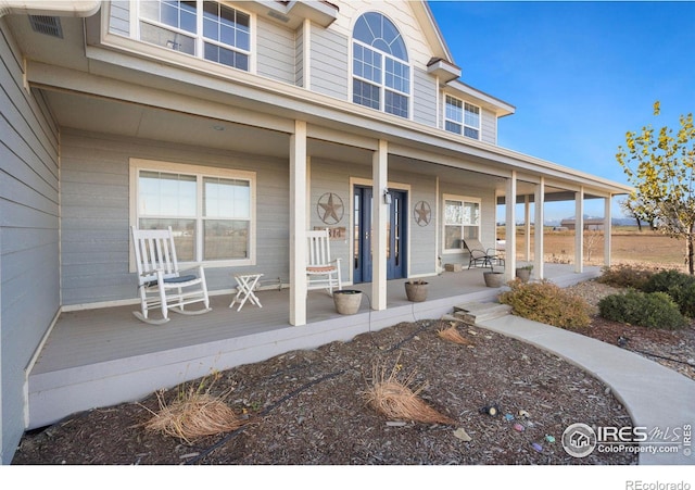 view of exterior entry featuring covered porch