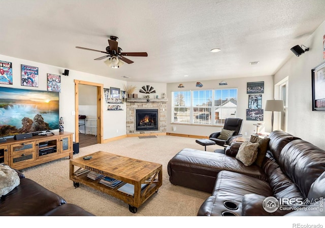 carpeted living room with ceiling fan, a fireplace, and a textured ceiling