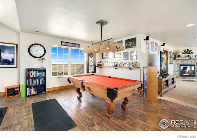 rec room featuring wood-type flooring, a textured ceiling, a fireplace, and billiards