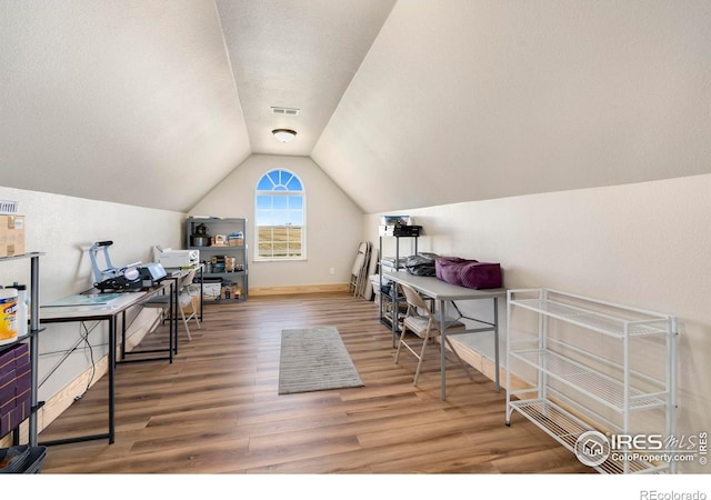 office featuring lofted ceiling, hardwood / wood-style flooring, and a textured ceiling