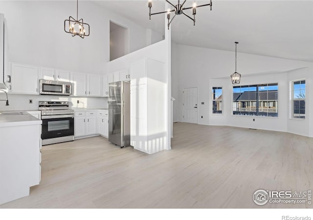 kitchen featuring pendant lighting, appliances with stainless steel finishes, sink, and white cabinets