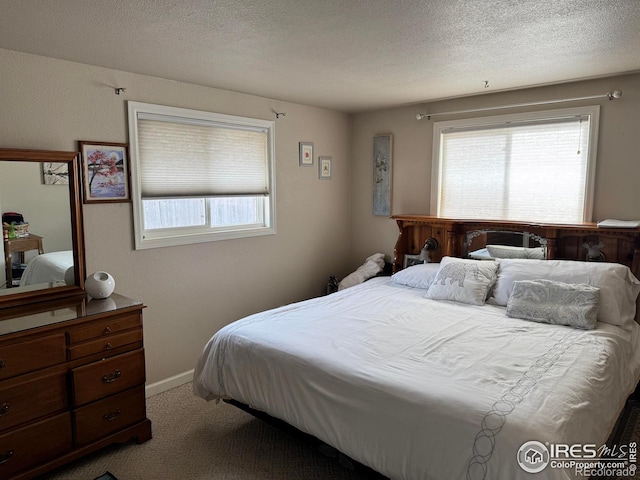 carpeted bedroom with a textured ceiling and baseboards