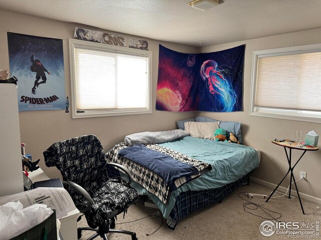 carpeted bedroom with a textured ceiling and baseboards