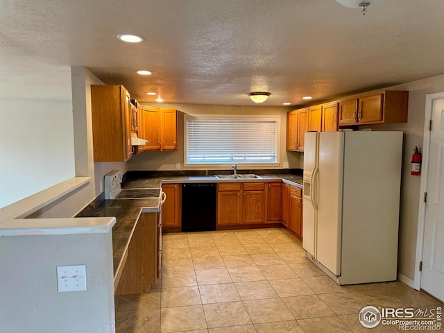 kitchen featuring light tile patterned floors, white appliances, a sink, brown cabinetry, and dark countertops