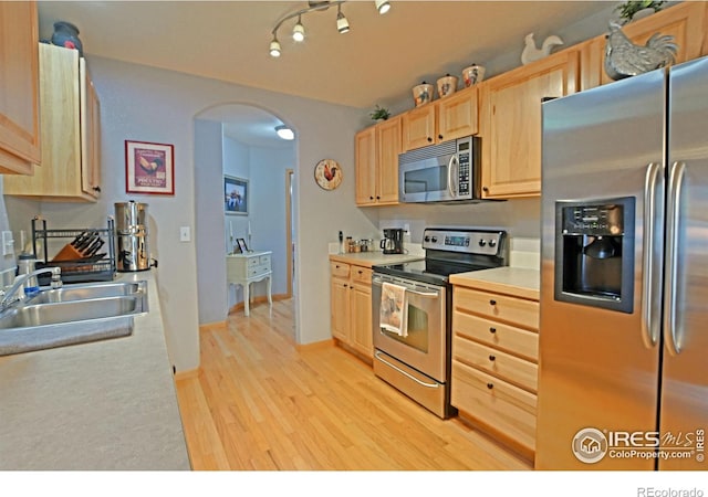 kitchen featuring light brown cabinetry, light hardwood / wood-style flooring, stainless steel appliances, and sink