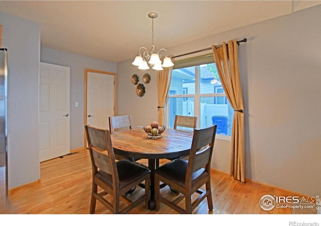 dining area featuring a notable chandelier and light wood-type flooring