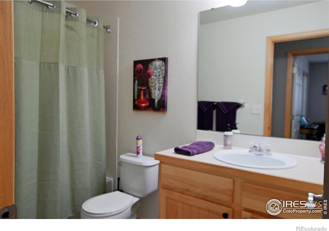 full bathroom with vanity, shower / tub combo, and toilet