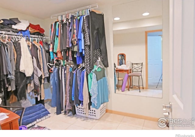 walk in closet with light tile patterned floors