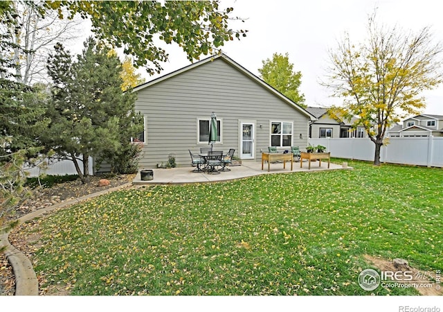 back of house with a patio area and a yard