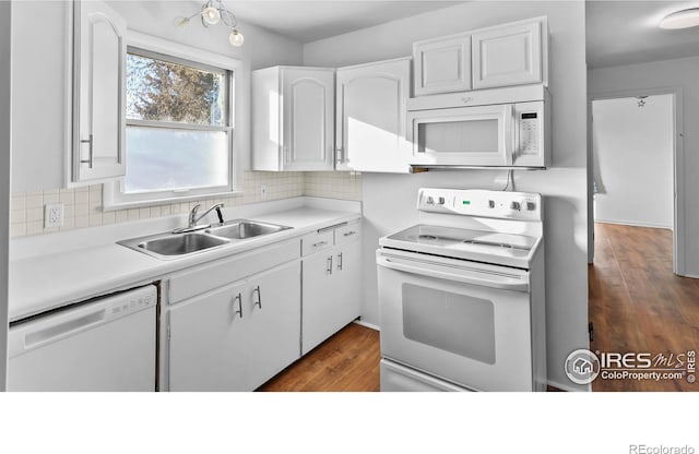 kitchen with white appliances, dark hardwood / wood-style floors, white cabinetry, and sink