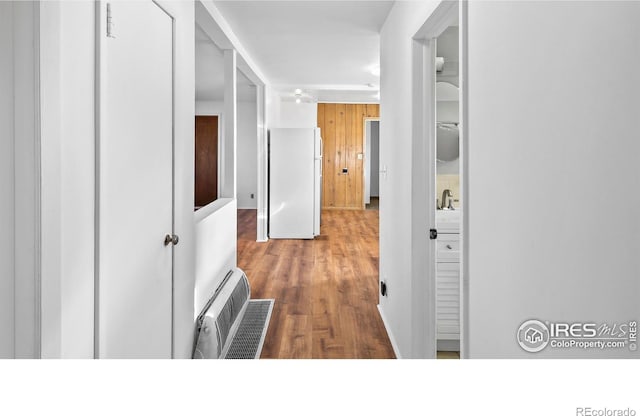 hall featuring wood-type flooring and sink