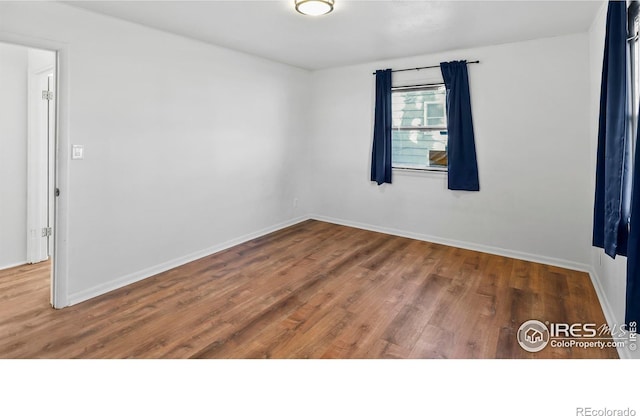 spare room with wood-type flooring