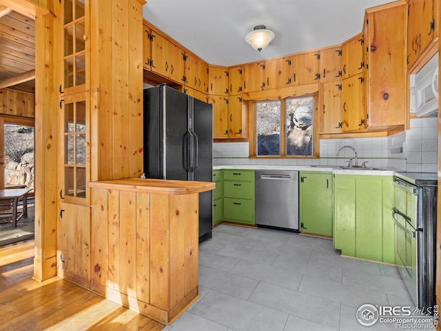 kitchen with decorative backsplash, black fridge, stainless steel dishwasher, and electric stove