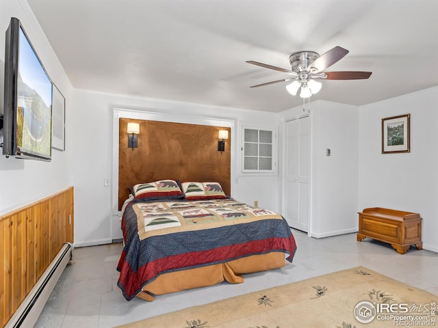 bedroom with a closet, baseboard heating, wood walls, and ceiling fan