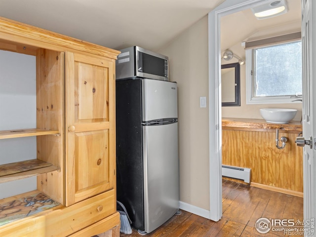 kitchen with stainless steel appliances, a baseboard heating unit, sink, dark hardwood / wood-style floors, and lofted ceiling