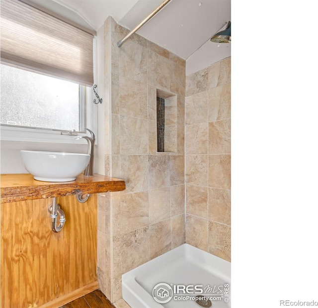 bathroom with a tile shower and sink