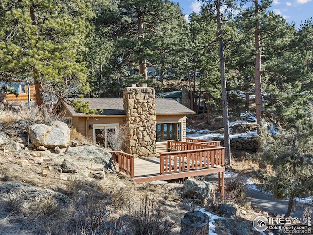 rear view of house featuring a wooden deck