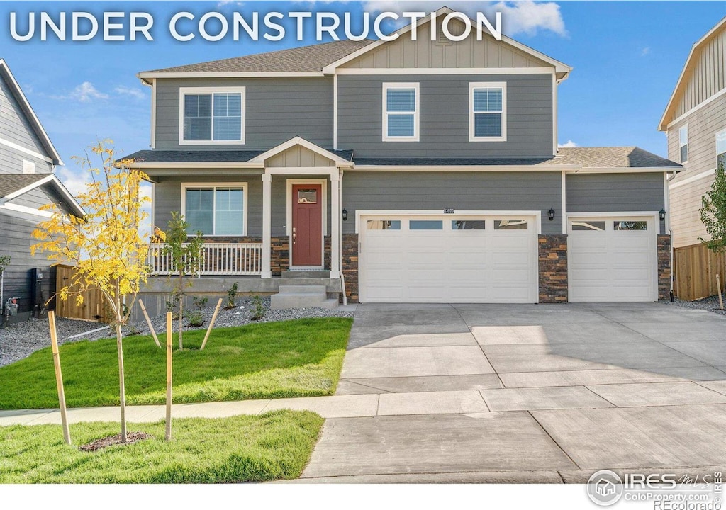 craftsman-style house with covered porch, a front yard, and a garage