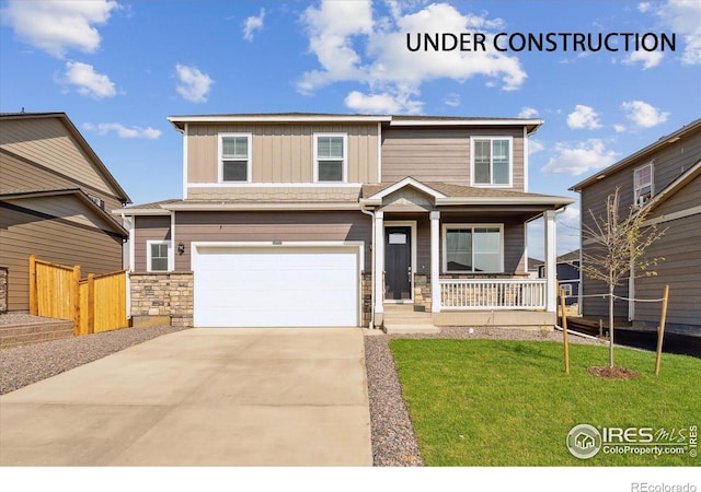 view of front of house featuring covered porch, a garage, and a front lawn