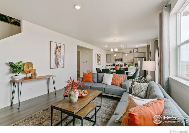 living room featuring dark hardwood / wood-style flooring and an inviting chandelier