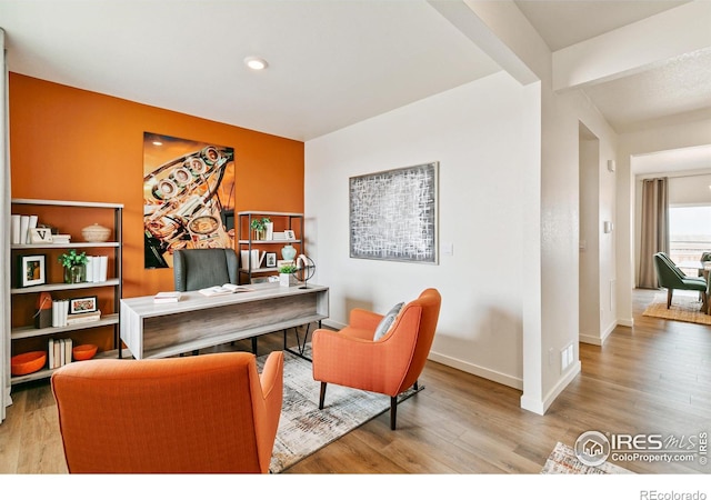 home office featuring beamed ceiling and light wood-type flooring